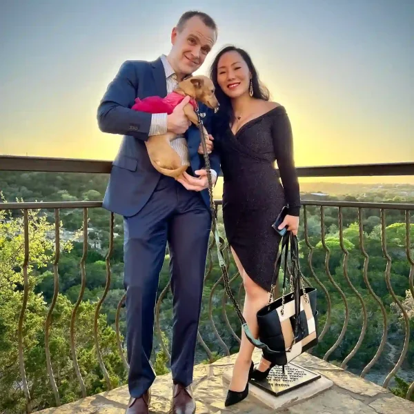 Yang Wang and her husband Dennard Mcinnis, founders of Lakeway Copperleaf Homestead assisted living, with therapy dog Mini overlooking the Texas Hill Country